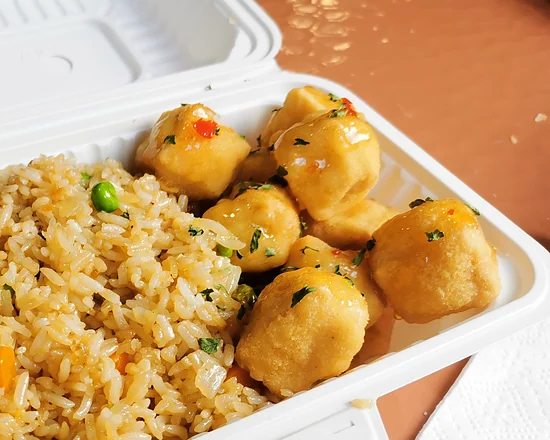 Chicken balls with vegetable fried rice in a takeout box